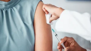 Woman receiving a vaccine injection with aluminum adjuvants in her arm