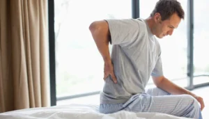 Man holding his lower back in pain, highlighting concerns about kidney issues linked to aluminum exposure