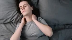 Woman lying in bed struggling to get up, raising concerns about aluminum cause chronic fatigue